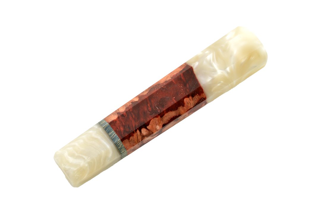 Un gros plan sur le manche « Wa » personnalisé n° 610 (137 mm, standard) de Made in Turkey révèle son cœur brun-rougeâtre aux veines marbrées inspirées de l’amboyna, ses extrémités d’un blanc nacré et un anneau métallique, qui témoignent d’un savoir-faire exceptionnel dans l’assemblage de la lame et du manche.
