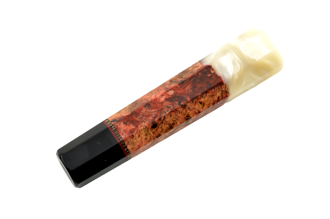 La poignée personnalisée Wa n° 612 - 135 mm (standard) de la marque Made in Turkey présente une extrémité noire brillante, une autre de couleur ivoire clair marbré, ainsi qu'une partie en bois brun rougeâtre aux veines tourbillonnantes au milieu, le tout sur fond blanc.