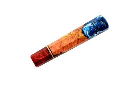 Le manche personnalisé « Wa-Handle » n° 643 - 139 mm (standard) de la marque « Made in Turkey » présente un motif de grain de bois rouge-brun, un centre en loupe de couleur brun doré et une extrémité en résine bleue tourbillonnante, le tout sur fond blanc. Il s'inspire des designs de manches de couteaux personnalisés.